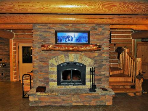 a stone fireplace with a television on top of it at Teton Hostel HideAway in Driggs