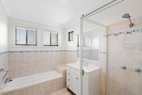 a bathroom with a tub and a sink and a shower at Holiday Haven, Unit 7, 30-32 Cypress Street Evans Head in Evans Head