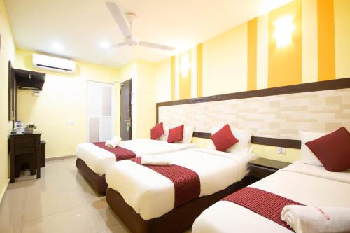 a room with three beds with red pillows at Sun Inns Hotel Meru Raya in Chemor