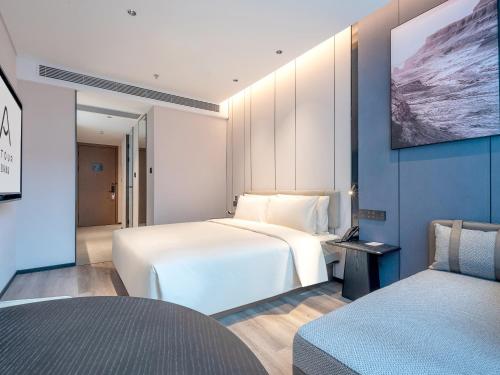 a hotel room with two beds and a tv on the wall at Atour Hotel Shenzhen Nanshan Mango Building in Shenzhen