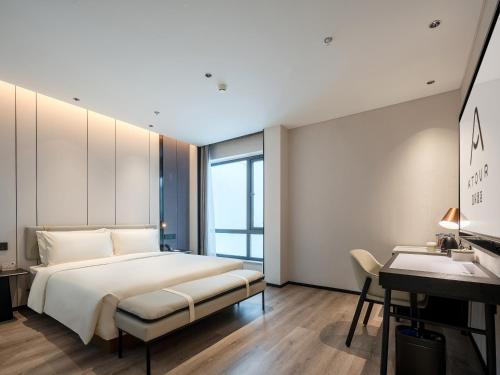 a bedroom with a bed and a desk at Atour Hotel Shenzhen Nanshan Mango Building in Shenzhen