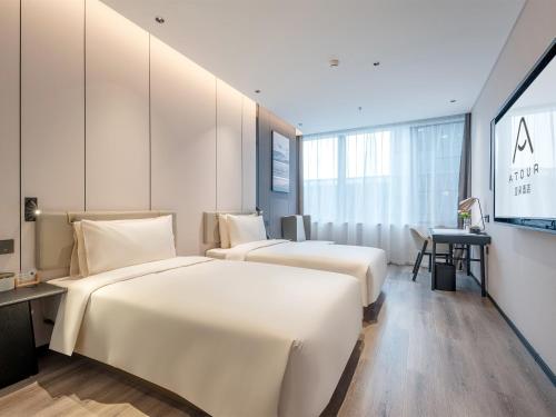 a hotel room with two beds and a desk at Atour Hotel Shenzhen Nanshan Mango Building in Shenzhen