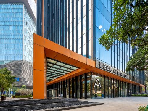 a large glass building with a sign on it at Atour Hotel Shenzhen Nanshan Mango Building in Shenzhen