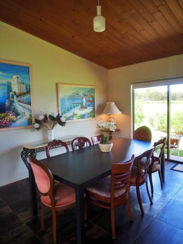 a dining room with a black table and chairs at Stanthorpe Heritage Estate in Dalveen