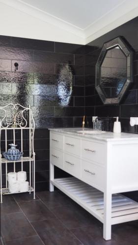 une salle de bain avec un lavabo blanc et un miroir dans l'établissement Stanthorpe Heritage Estate, à Dalveen