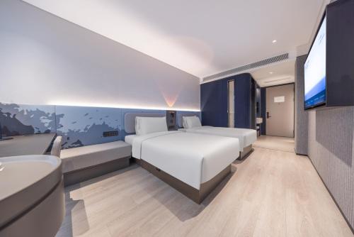 揚州市にあるAtour Light Hotel Yangzhou Dongguan Street Ancient Canal Wharfのベッドルーム(ベッド1台、バスタブ、テレビ付)