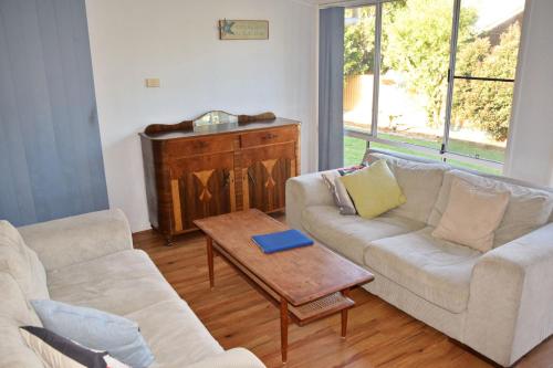 a living room with two couches and a coffee table at Mountain View Hat Head - Bring your own linen. in Hat Head