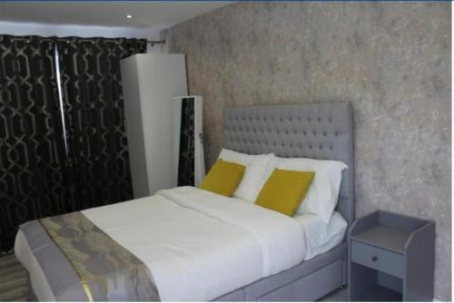 a bedroom with a bed with two yellow pillows at Mini Cosy Studio Flat Milton Keynes in Milton Keynes