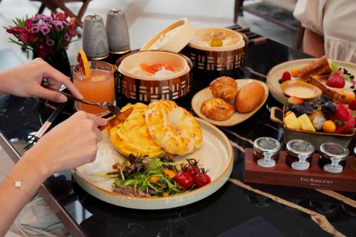a table with a plate of food and a person cutting at The Barracks Hotel Sentosa by Far East Hospitality in Singapore