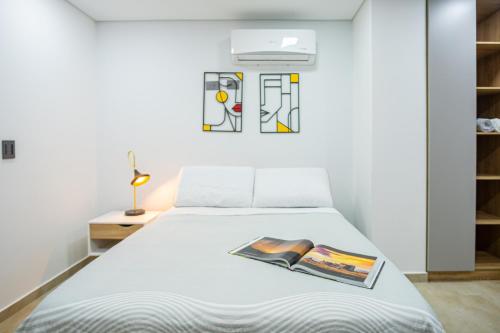 a bedroom with a bed with a book on it at 102 Norte cali - The view in Cali