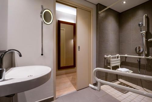 a bathroom with a sink and a shower at Mövenpick Hotel Hamburg City in Hamburg
