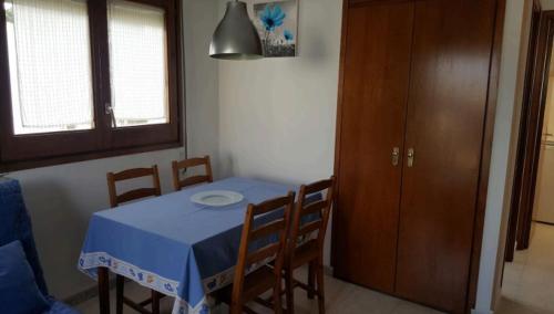 a dining room table with a blue table and chairs at Pequeño estudio muy lindo a 500 m de la playa in L'Escala
