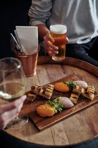a table with a plate of food and a glass of beer at Yarra Valley Lodge in Wonga Park