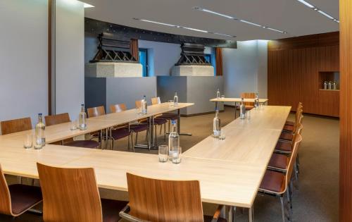 a large conference room with long tables and chairs at Mövenpick Hotel Hamburg City in Hamburg