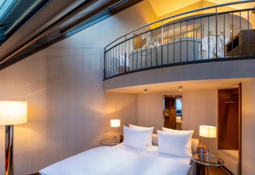 a bedroom with a white bed and a balcony at Mövenpick Hotel Hamburg City in Hamburg