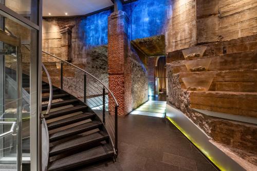 a staircase in a building with a brick wall at Mövenpick Hotel Hamburg City in Hamburg