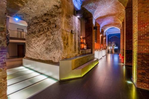 a hallway in a building with a stone wall at Mövenpick Hotel Hamburg City in Hamburg