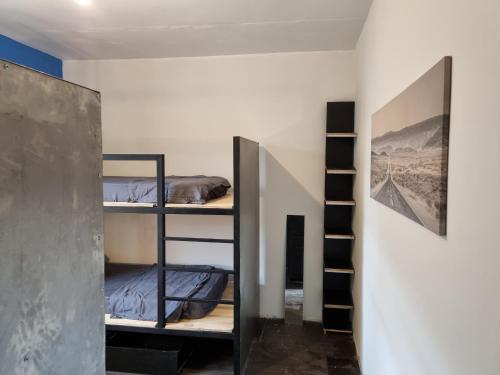a room with three bunk beds and a staircase at La casa del mochilero in Mexico City