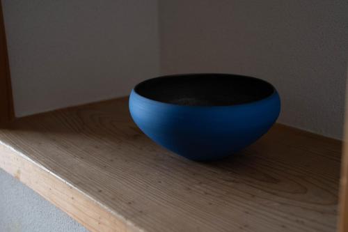 a blue bowl sitting on top of a wooden shelf at Hanare Yado Yosizumi in Ito
