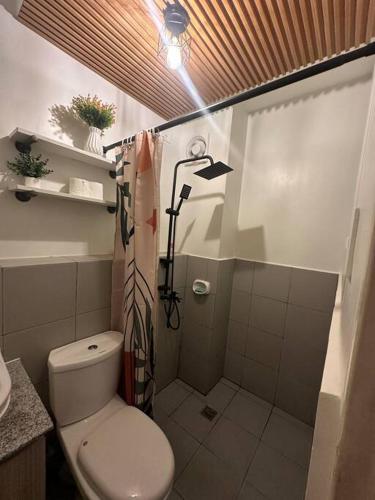 a small bathroom with a toilet and a shower at Happy Nest at La Bella Condo Banilad Mandaue Cebu 2 Bedrm Free wifi 6pax max in Banilad