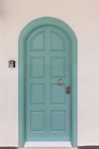a blue door in a white wall at Teal Guesthouse in Batroûn