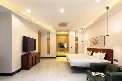 a hotel room with a bed and a flat screen tv at The One Hotel壹心生活美学酒店 in Yangshuo