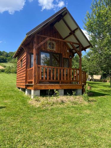 une grande cabine en bois avec une grande terrasse dans un champ dans l'établissement Les cabanes au revers du noitel, à Oëy