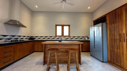 a kitchen with a counter and a refrigerator at Villa Tegal lovina in Buleleng