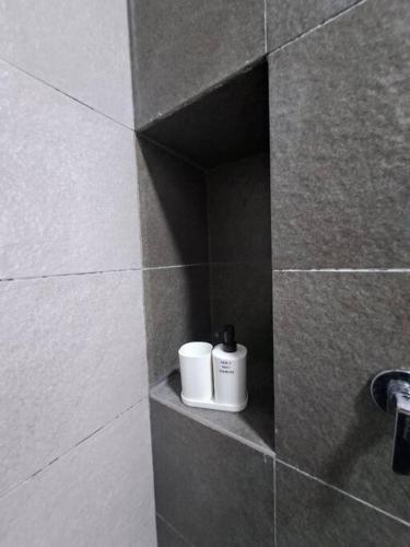 two cups are sitting on a shelf in a bathroom at AirHomestay Ostia Bangi Pool & Sunset view Wifi in Bandar Baru Bangi