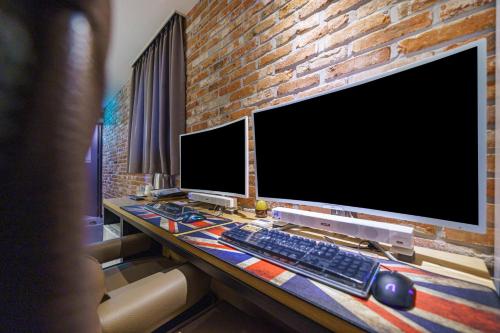 a desk with two computer monitors and a keyboard and mouse at Hotel Yaja Pyeongtaek St in Pyeongtaek