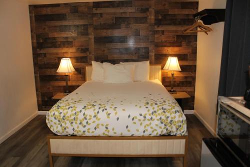 a bedroom with a bed and two lamps on two tables at Cedarwood Inn of Ashland in Ashland