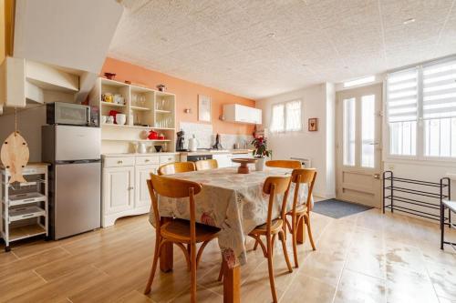 une cuisine avec une table et des chaises dans une pièce dans l'établissement LA ROUSSETTE, à Marseillan