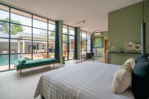 a bedroom with a large bed and a pool at Rouge - Loft Emylia in Ubud