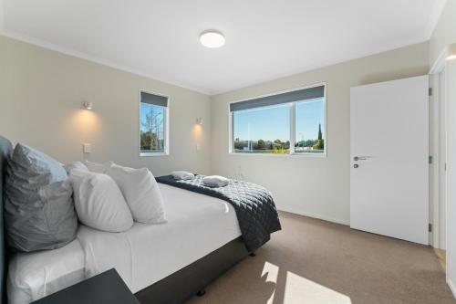 a bedroom with a white bed and a window at Haven at the Heights - Taupo in Taupo