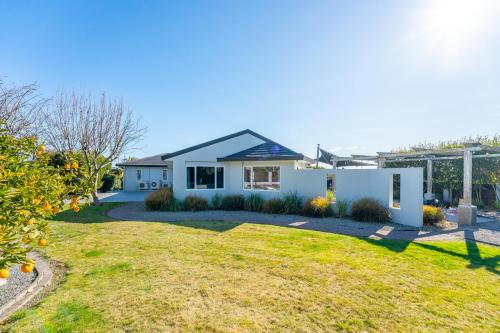 a white house with a yard at Haven at the Heights - Taupo in Taupo