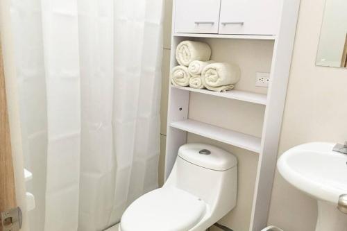 a white bathroom with a toilet and a sink at Bello espacio en zona rodeada de naturaleza Apt 2 in Curridabat
