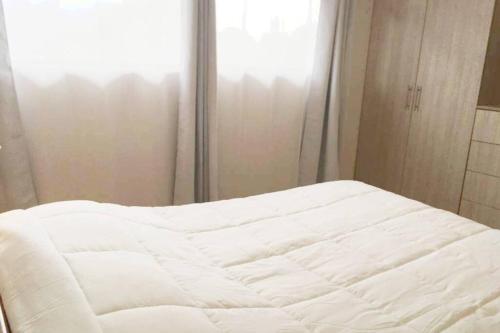a white bed in a room with a window at Bello espacio en zona rodeada de naturaleza Apt 2 in Curridabat