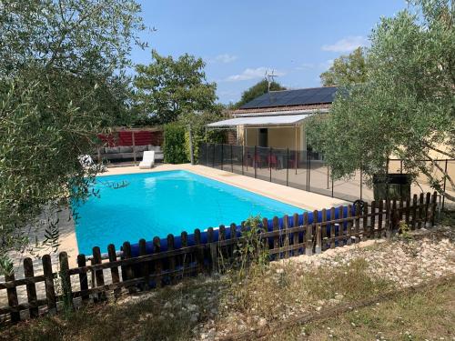 une piscine entourée d'une clôture dans l'établissement Maison de campagne, à Cieurac