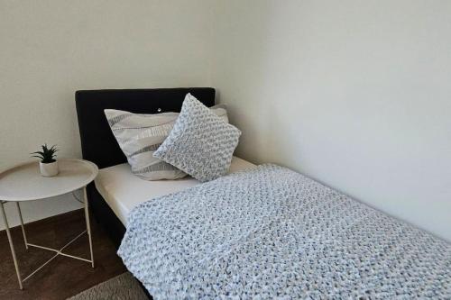 a bedroom with a bed with pillows and a table at Appartement Nähe Zentrum Steyr in Behamberg