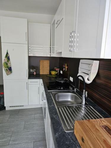 a kitchen with white cabinets and a stainless steel sink at Appartement Nähe Zentrum Steyr in Behamberg
