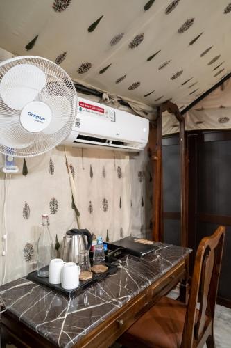 a kitchen with a counter top with a fan at Dev Bhoomi Farms & Cottages in Dharamshala