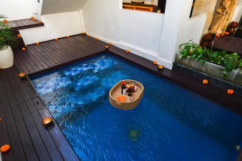 an indoor pool with a small boat in the water at Pure Peace, only 5 Min to Ubud! in Ubud