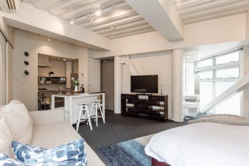 a bedroom with a bed and a living room at Fleg Higashi Azabu in Tokyo