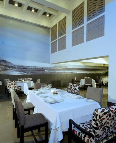 a dining room with a white table and chairs at Crowne Plaza Lima by IHG in Lima