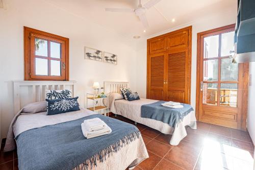 a bedroom with two beds and a window at E415 Can Xisco by Mallorca Villa Selection in Port de Pollensa