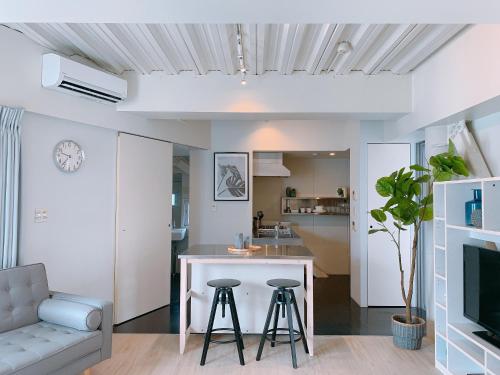 a kitchen and living room with a table and stools at Fleg Higashi Azabu in Tokyo
