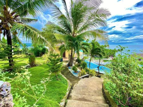 a resort with a swimming pool and palm trees at Azure Camotes Resort Hotel in Camotes Islands