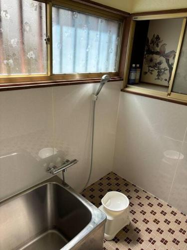 a small bathroom with a sink and a toilet at 繁華街まで徒歩10分の好立地 観光や食事を楽しむことができます in Amami