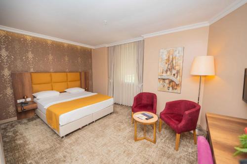 a hotel room with a bed and a table and chairs at Boris Hotel Beylikdüzü in Beylikduzu
