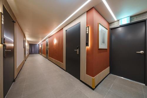 a hallway with a row of doors in a building at Brown Dot Hotel Geumchon in Paju